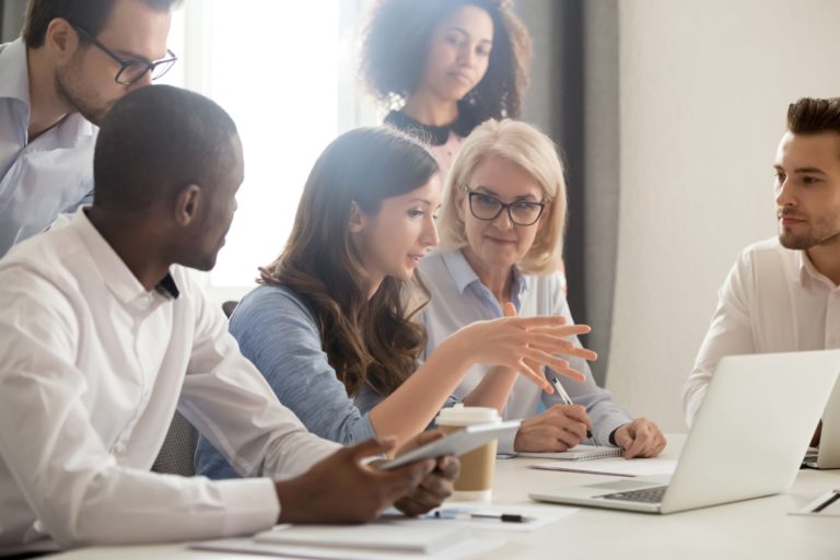 business people sitting around laptop talking