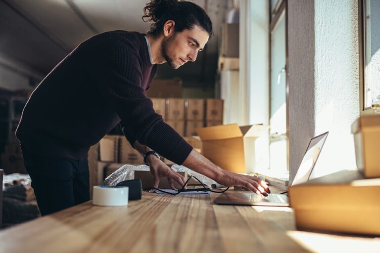 man at desk looking at laptop