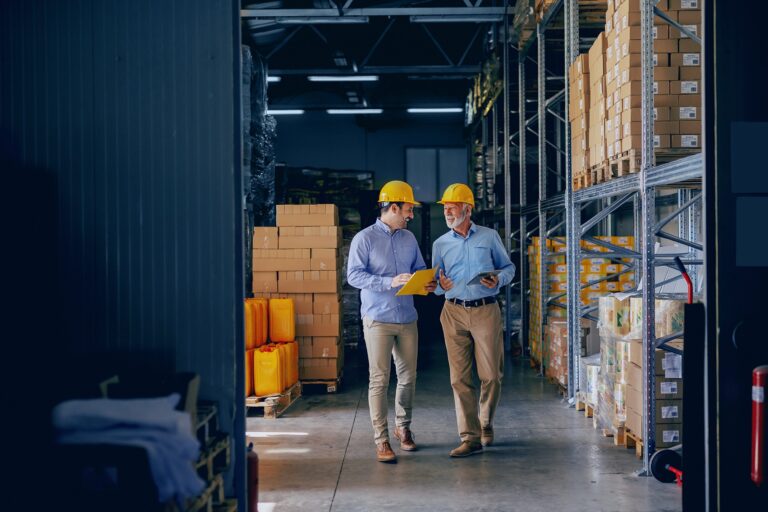 two men in hardhats talking in warehouse