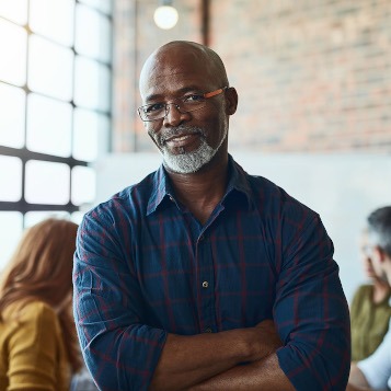 man with folded arms smiling at camera