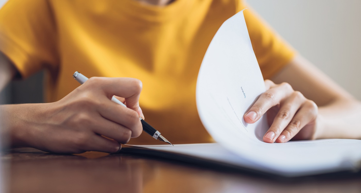 woman writing on paper at desk close up
