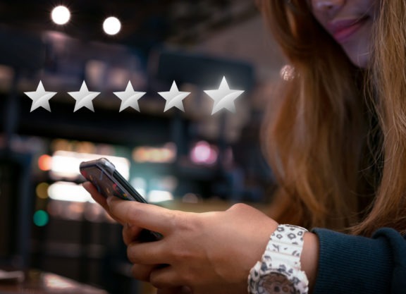 woman on phone giving 5 star review