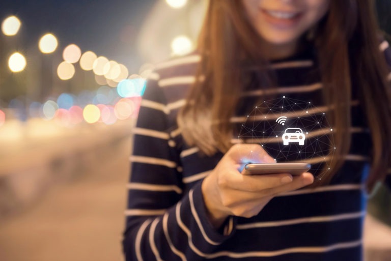 Close up woman hand orders a taxi from his mobile smartphone application