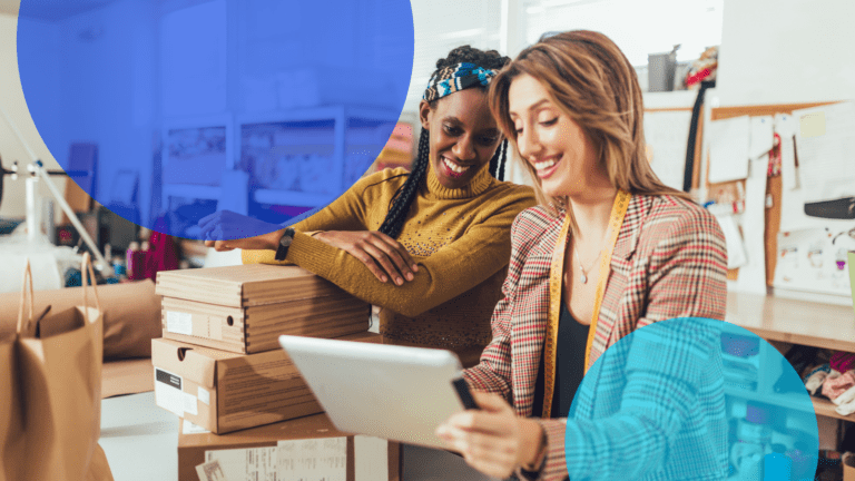 two women in store looking at tablet smiling 2