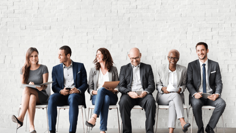 three business men and two business women sitting next to each othe