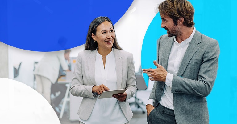 man and woman talking and smiling in office