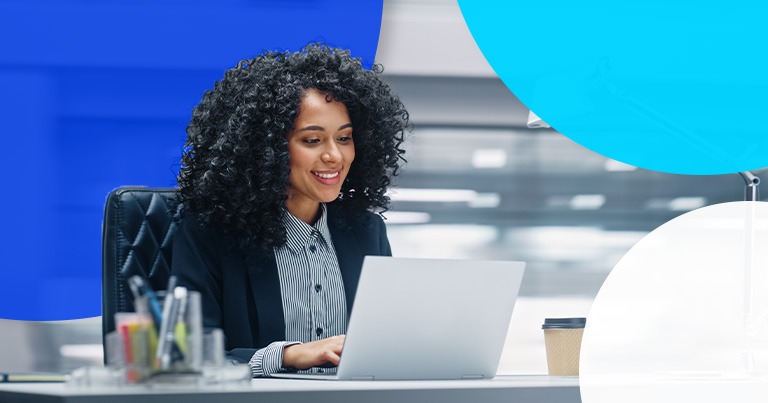 woman at desk looking at laptop