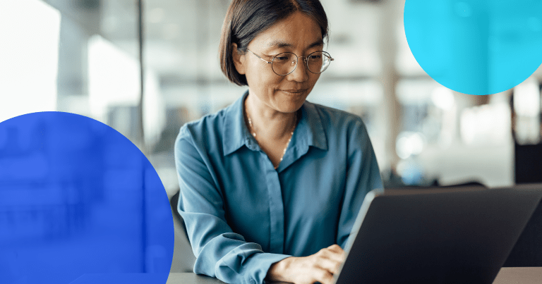 woman typing at a computer wearing glasses as she works on her Order-to-Cash process optimization. Two blue dots are on the image