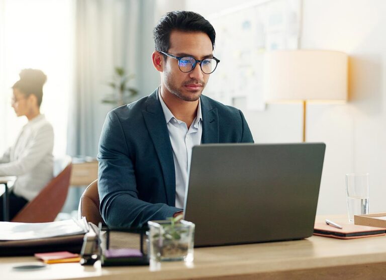 a man sitting in an office working on his computer