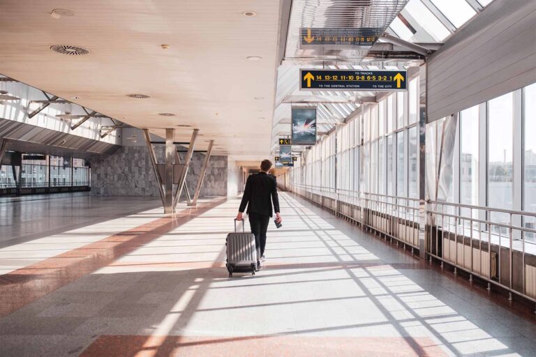 a man walking through an empty airport dragging a suitcase