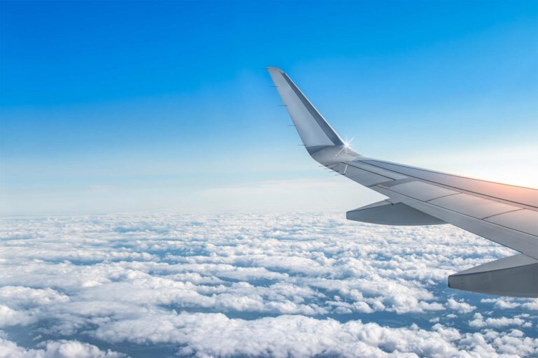 view from the airplane window looking at the wing and the clouds