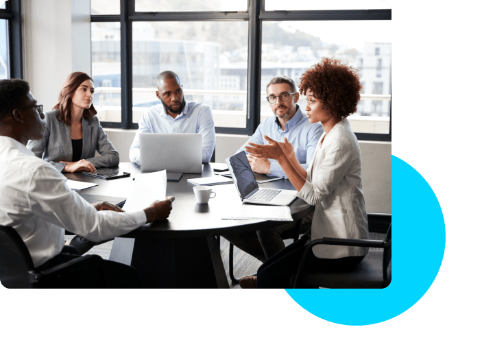 people sitting around a table looking a woman talking with a blue circle in the corner