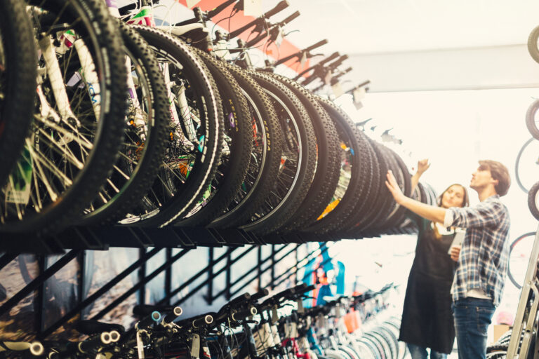 Manager and customer in a bike shop looking at bikes