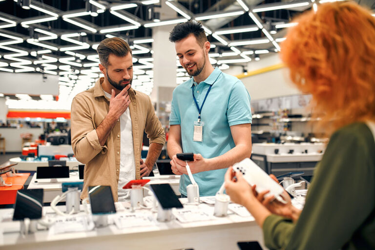 two men discussing phone at tech store