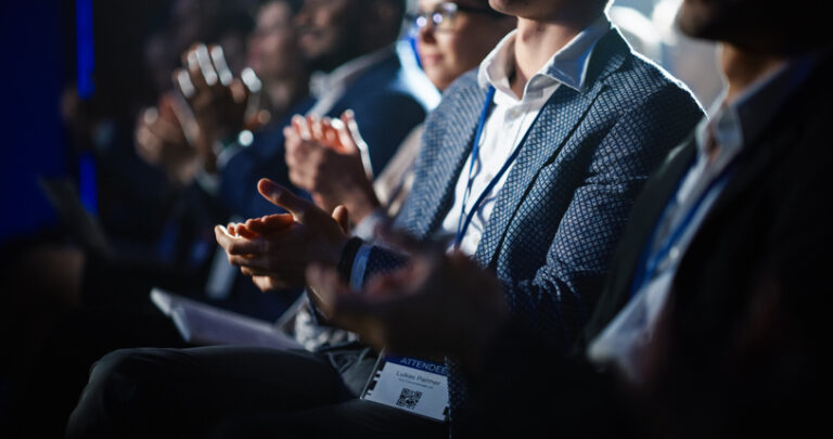 close up of people clapping at conference
