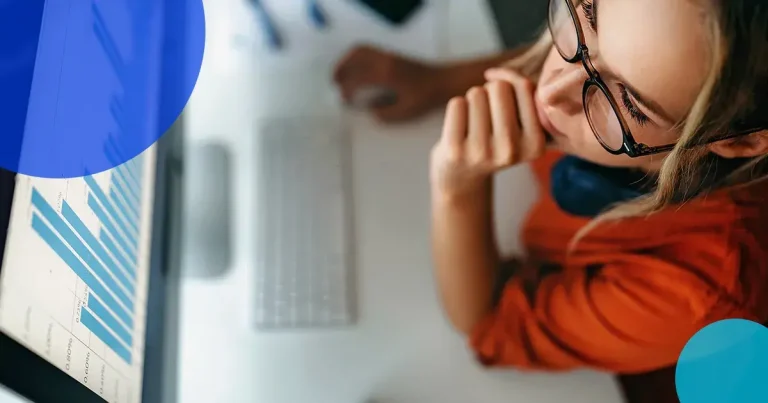 Woman with glasses staring at computer screen with data